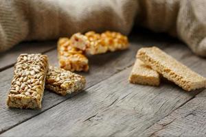 Assorted kozinaki, on old vintage background, with burlap fabric. Country style. Delicious sweets from the seeds of sunflower, sesame and peanuts, covered with shiny glaze. photo