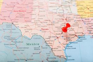 Red clerical needle on a map of USA, Texas and the capital Austin. Closeup Map Texas with Red Tack photo