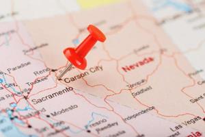 Red clerical needle on a map of USA, Nevada and the capital Carson City. Closeup Map Nevada with Red Tack photo