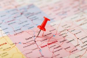 Red clerical needle on a map of USA, New Mexico and the capital of Santa Fe. Close up map of new mexico with red tack photo