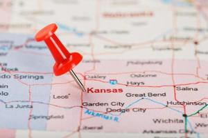 Red clerical needle on a map of USA, Kansas and the capital Topeka. Close up map of Kansas with red tack photo