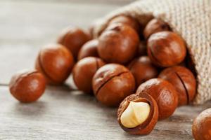 Macadamia nut on a wooden table in a bag, closeup, top view photo