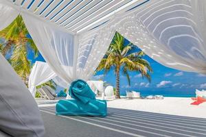 increíble escena de playa tropical con dosel blanco y cortina para un lujoso concepto de relajación de verano. cielo azul con arena blanca para el fondo del paisaje de la playa soleada y vacaciones de verano o diseño de vacaciones foto