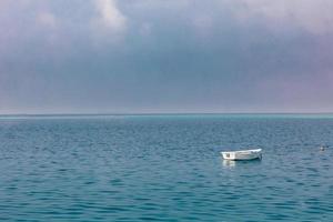 Serenity, lonely boat on blue sea. Beautiful seascape with horizon and sky photo
