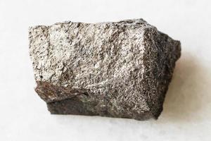 roca de pirotita de pirrotita sin pulir sobre mármol blanco foto