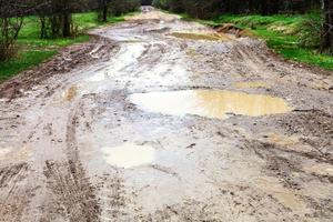 puddles on dirty country road in spring photo