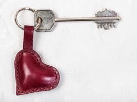 llave con llavero en forma de corazón en placa de hormigón foto