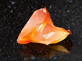 crystal of cornelian red chalcedony on dark photo