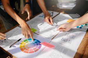 UX developer and ui designer brainstorming about mobile app interface wireframe design with customer breif and color code at office. photo
