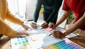 UX developer and ui designer brainstorming about mobile app interface wireframe design with customer breif and color code at office. photo