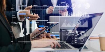 Businessman hand Project manager working and update tasks and Gantt chart scheduling virtual diagram.with smart phone, tablet and laptop in office. photo