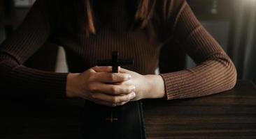 Woman praying on holy bible in the morning.Woman hand with Bible praying. Christian life crisis prayer photo