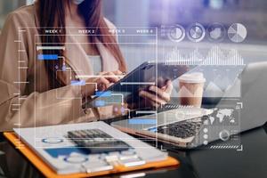Businessman hand Project manager working and update tasks and Gantt chart scheduling virtual diagram.with smart phone, tablet and laptop in office. photo