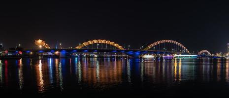 viaje en concepto de vietnam, vista nocturna del paisaje con espectáculo de iluminación del puente del dragón a través del río en da nang, vietnam. foto