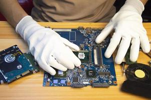 Technician repairing computer motherboard, notebook motherboard photo