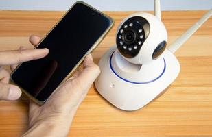 man using smart phone with ip camera photo
