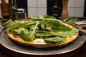 pizza brasileña con tomates secos, rúcula y mozzarella foto