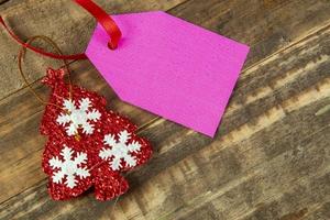 elementos decorativos de navidad junto a la tarjeta con cinta roja y espacio para escribir foto