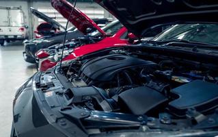 Auto repair shop. Cars open bonnet parked in garage for repair and maintenance service. Car check up at service station. Car waiting for inspection in auto repair shop. Car maintenance and checklist. photo