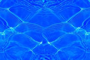 Defocus blurred transparent blue colored clear calm water surface texture with splashes and bubbles. Trendy abstract nature background. Water waves in sunlight with copy space. Blue watercolor shining photo