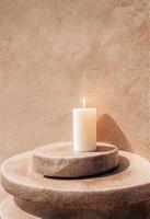 White candle on natural rock pedestal. Product presentation mockup,