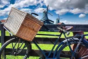 Bicycle with windmill and blue sky background. Scenic countryside landscape close to Amsterdam in the Netherlands. photo