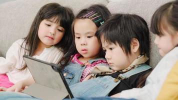 Group of children using tablet in classroom, Multi-ethnic young boys and girls happy using technology for study and play games at elementary school. Kids use technology for education concept. photo