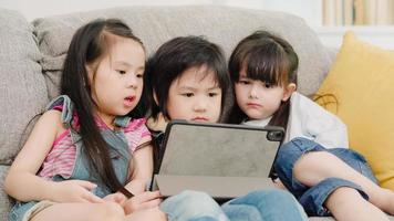 Group of children using tablet in classroom, Multi-ethnic young boys and girls happy using technology for study and play games at elementary school. Kids use technology for education concept. photo