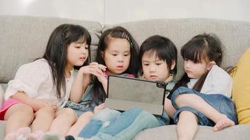 Group of children using tablet in classroom, Multi-ethnic young boys and girls happy using technology for study and play games at elementary school. Kids use technology for education concept. photo