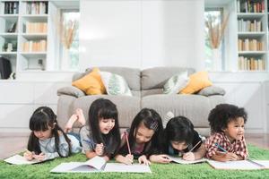 Group of children drawing in classroom, Multi-ethnic young boys and girls happy funny study and play painting on paper at elementary school. Kids drawing and painting at school concept. photo