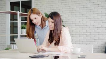 mujeres de negocios asiáticas creativas e inteligentes atractivas con ropa informal inteligente que trabajan en una computadora portátil mientras están sentadas en el escritorio de la oficina. las mujeres de estilo de vida trabajan en el concepto de oficina. foto