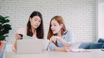 mujeres de negocios asiáticas creativas e inteligentes atractivas con ropa informal inteligente que trabajan en una computadora portátil mientras están sentadas en el escritorio de la oficina. las mujeres de estilo de vida trabajan en el concepto de oficina. foto