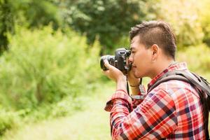 Man photographer with big backpack and camera taking photo of sunset mountains Travel Lifestyle hobby concept adventure active vacations outdoor - Boost up color Processing.