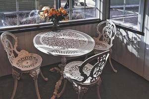 Empty vintage wrought iron garden table and chairs in public cafe inside an autumn day. photo