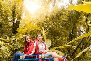 felices jóvenes viajeros asiáticos con un coche de tracción en las 4 ruedas fuera de la carretera en el bosque, una pareja joven que busca direcciones en el mapa y otros dos disfrutan en un coche de tracción en las 4 ruedas. joven mujer y hombre asiáticos de raza mixta. foto