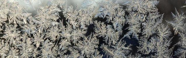 Snowflakes frost rime macro on window glass pane photo