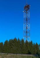 repetidor de tv de torre sobre fondo de cielo azul foto