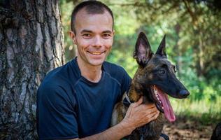 young Caucasian hipster spends time with his dog in the park on a sunny summer day. The concept of a pet as a family member photo