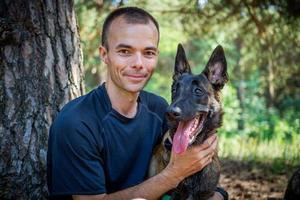 young Caucasian hipster spends time with his dog in the park on a sunny summer day. The concept of a pet as a family member photo