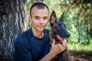 young Caucasian hipster spends time with his dog in the park on a sunny summer day. The concept of a pet as a family member photo