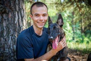 young Caucasian hipster spends time with his dog in the park on a sunny summer day. The concept of a pet as a family member photo