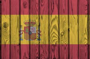 Spain flag depicted in bright paint colors on old wooden wall. Textured banner on rough background photo