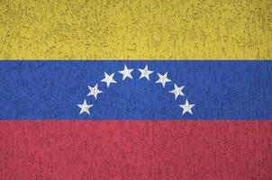 bandera de venezuela representada en colores de pintura brillante en la antigua pared de yeso en relieve. banner texturizado sobre fondo áspero foto