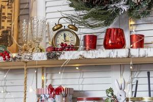 mesa en la cocina con utensilios de cocina y estanterías decoradas con juguetes navideños foto