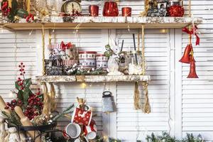 mesa en la cocina con utensilios de cocina y estanterías decoradas con juguetes navideños foto