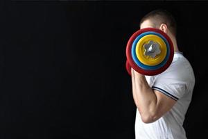 A strong, healthy man with muscles, training at home with a barbell. Fitness at home. photo