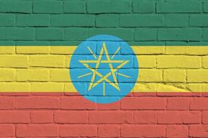 Ethiopia flag depicted in paint colors on old brick wall. Textured banner on big brick wall masonry background photo