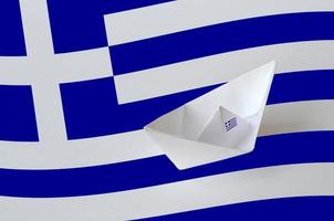 bandera de grecia representada en el primer plano de la nave de origami de papel. concepto de artes hechas a mano foto