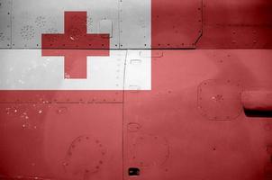 Tonga flag depicted on side part of military armored helicopter closeup. Army forces aircraft conceptual background photo