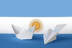 Argentina flag depicted on paper origami airplane and boat. Handmade arts concept photo